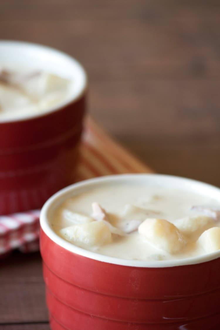 Close-up of creamy ham and potato soup with heavy cream in a red ramekin