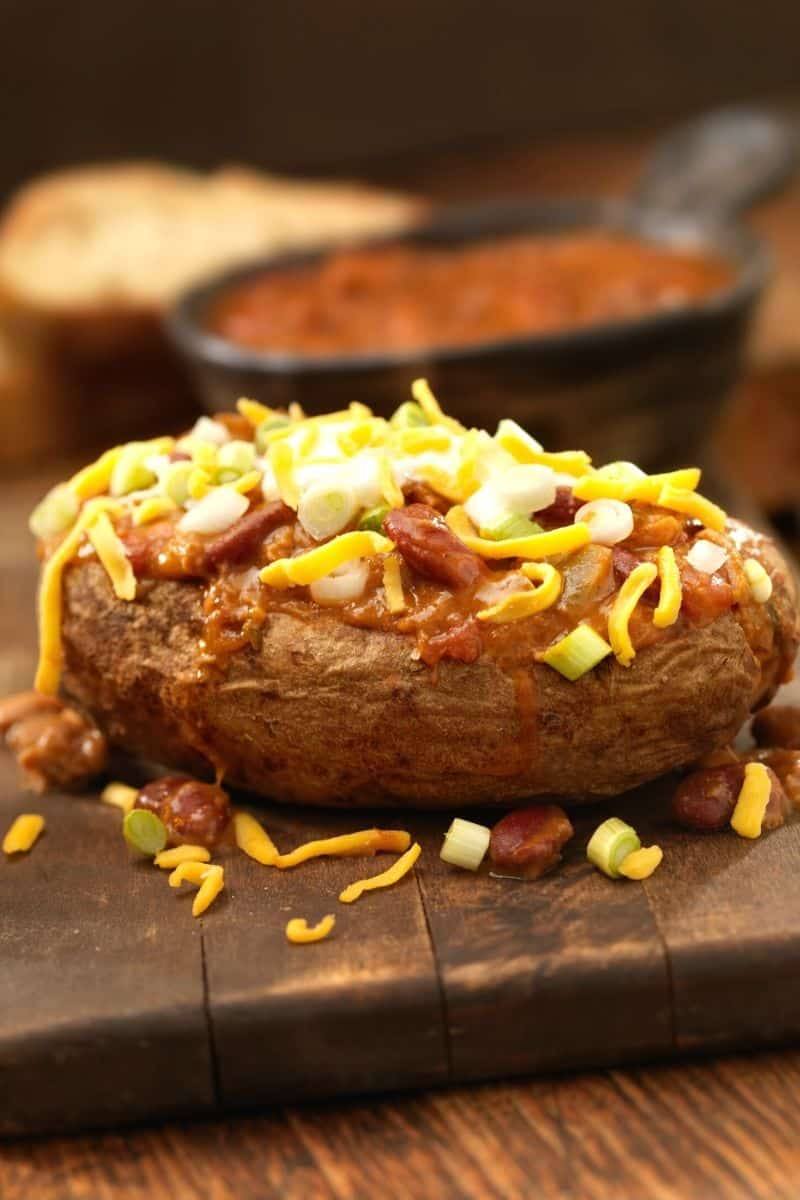 chili baked potato on a cutting board