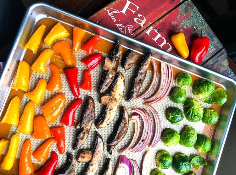 sliced peppers, mushrooms, onions and brussels sprouts on sheet pan to be used in Mediterranean roasted vegetables