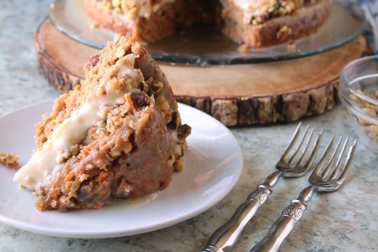 closeup of best carrot cake recipe slice on a white plate next to two forks