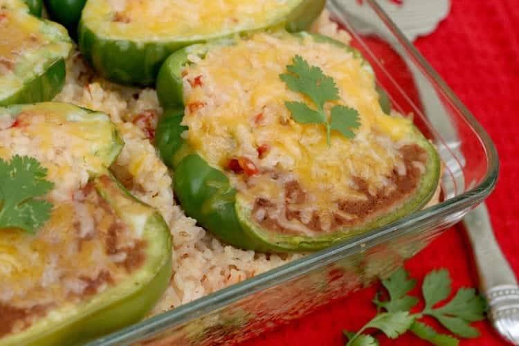 Close-up of a stuffed pepper half filled with refried beans and Mexican rice under melted cheese