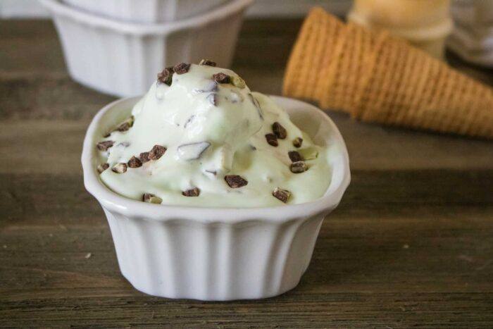 one scoop of mint chip no-churn ice cream served in a white square dessert dish