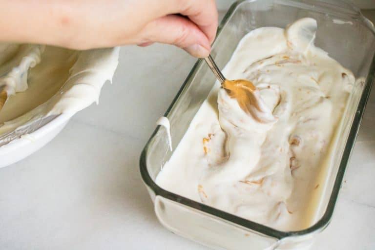peanut butter on a spoon being mixed into base for no-churn peanut butter ice cream