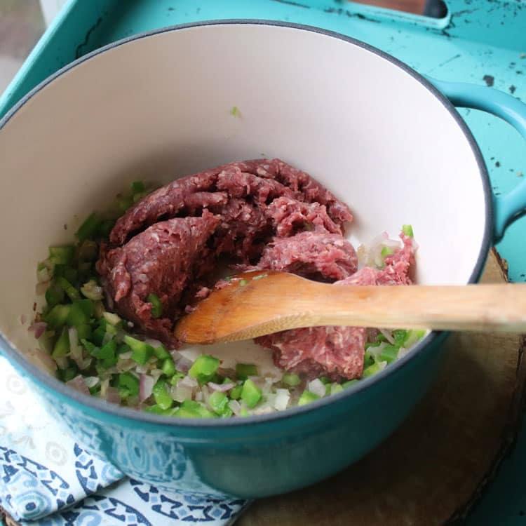Cooking ground beef with peppers and onions in a pot