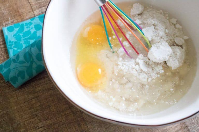 Mixing bowl with cake mix, eggs and oil being wisked together