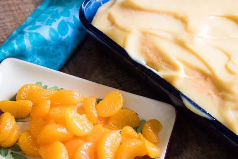 Cake with vanilla layer and mandarin orange slices ready to be placed on top