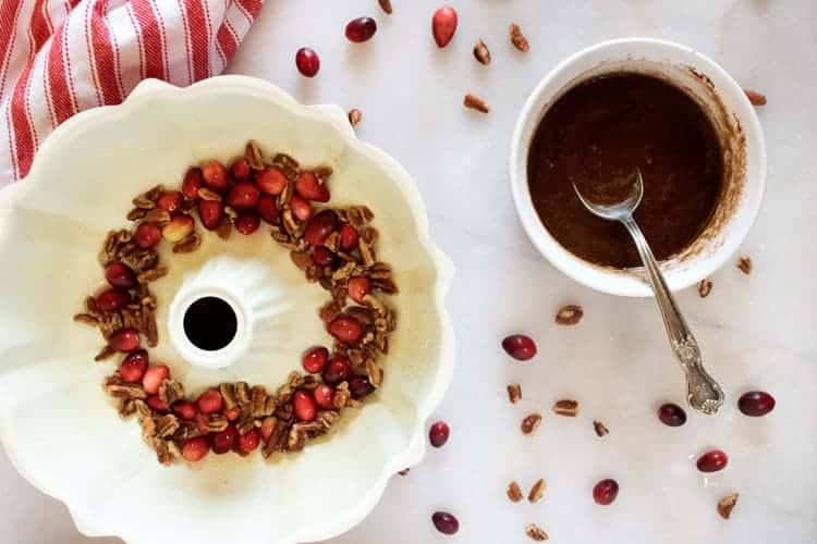 layering cranberries and pecans in the bundt cake pan