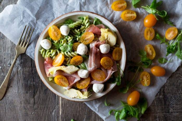 An easy recipe for pesto pasta salad using homemade pesto, mozzarella, artichokes and prosciutto. An easy summer dinner ready in no time