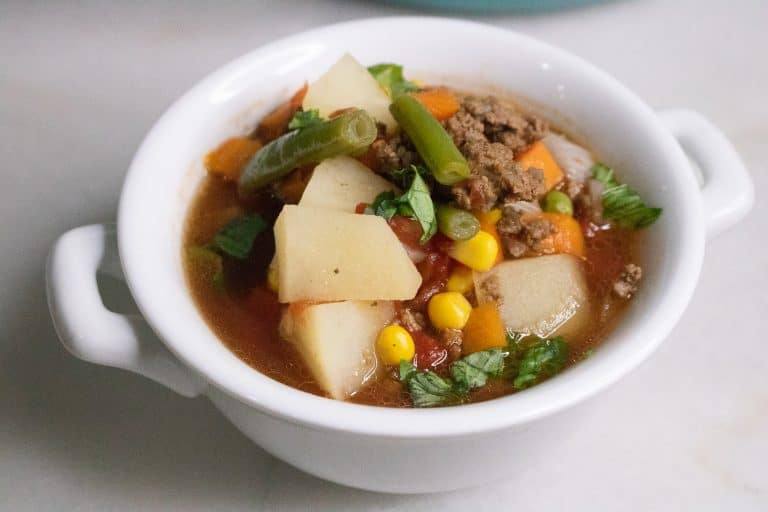 Bowl of Poor Man's Soup with ground beef, potatoes, corn and green beans