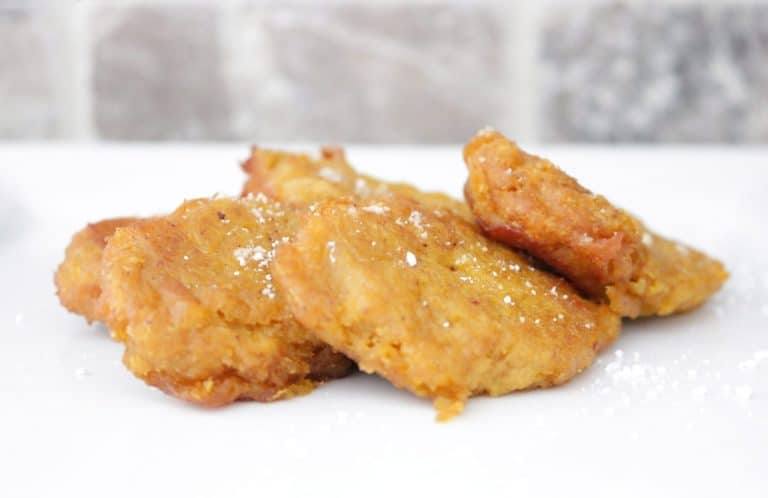 Side view of crispy fried pumpkin patties sprinkled with powdered sugar