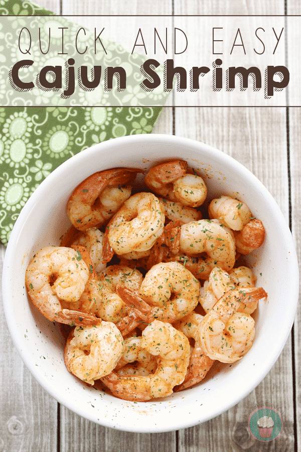 Quick and easy Cajun shrimp in a white bowl on a rustic wooden table with a green patterned napkin