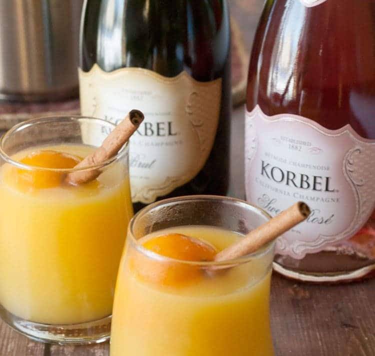 Warm mulled mimosa in small glasses garnished with cinnamon sticks