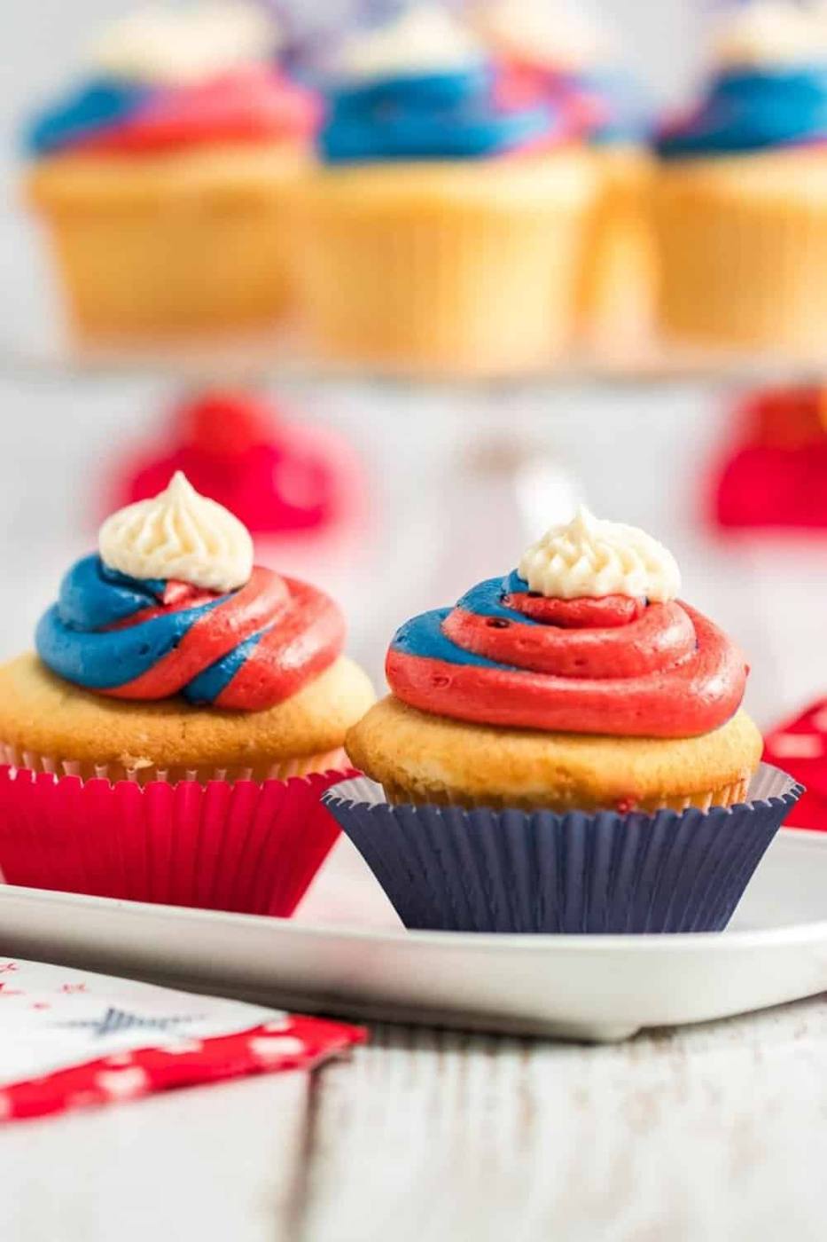Red white and blue cupcakes with patriotic frosting swirl on a white surface
