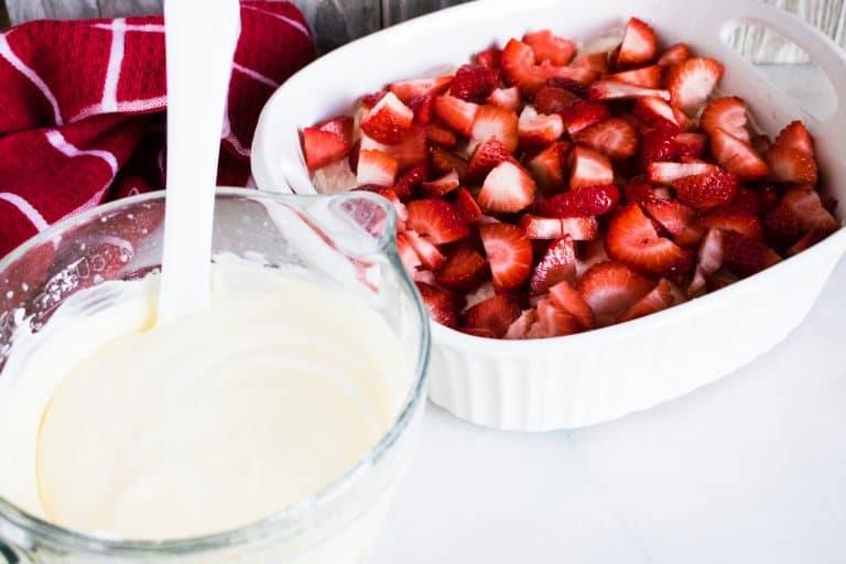 Strawberries on top of the cream cheese layer and pudding mixed ready for the next layer
