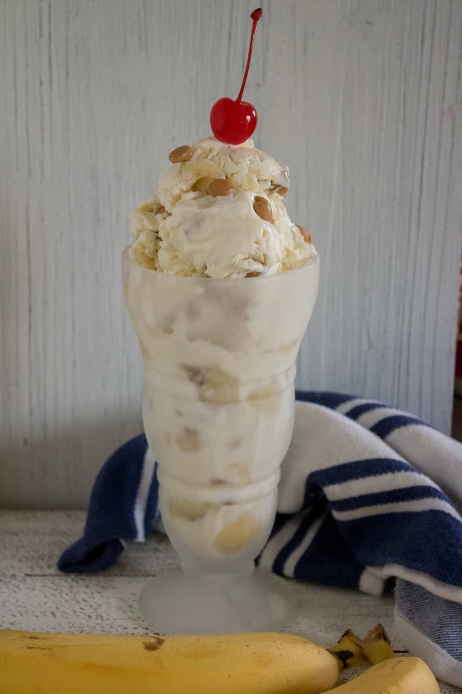 Reese's Chips & Banana No-Churn Easy Ice Cream served in a glass sundae dish and topped with a cherry