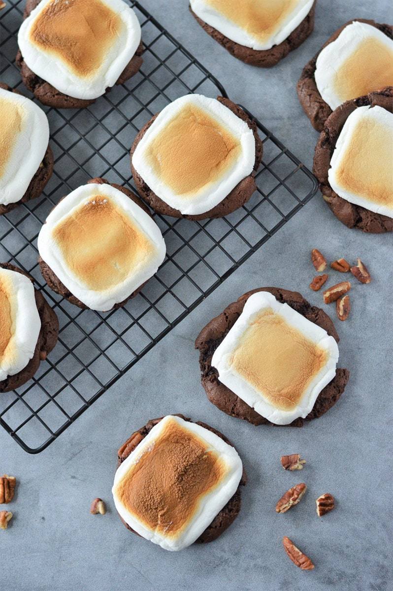 lots of rocky road cookies on gray table and black cooling rack