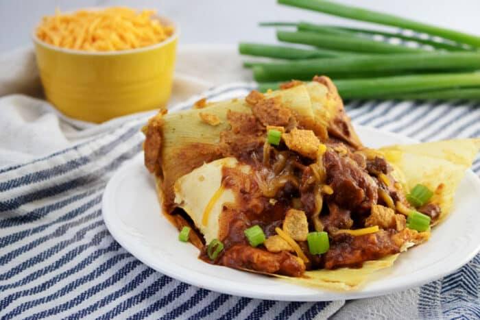 tamales with chili con carne on white plate