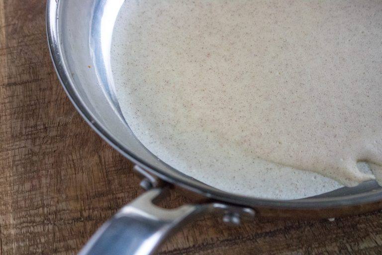 close-up of a crepe cooking in a silver pan