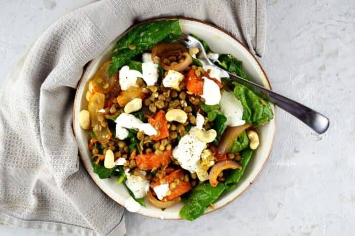Overhead shot of squash salad with feta cheese, lentils and spinach