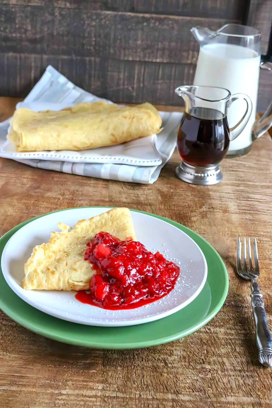 straeberry crepes being served on a plate