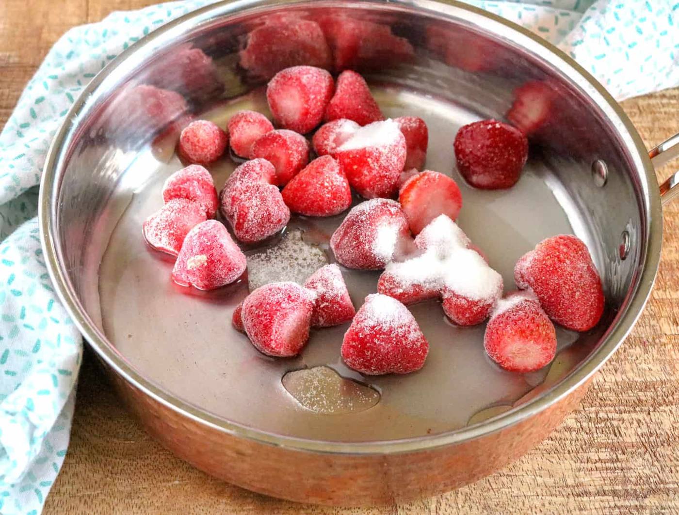 the strawberries cooking in a pan for the sauce