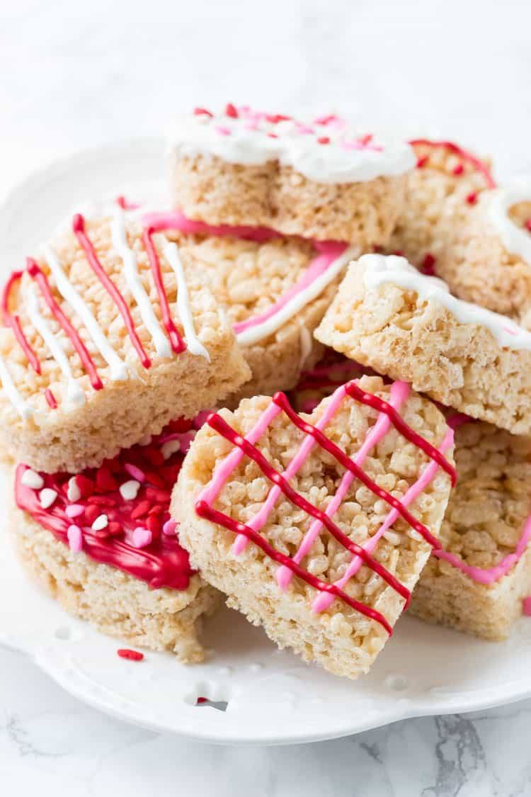 These Valentine's Rice Krispie treats are an easy, fun & festive recipe for February 14th. Kids will love making them, and they're a perfect treat to bring to school or Valentine's day parties.
