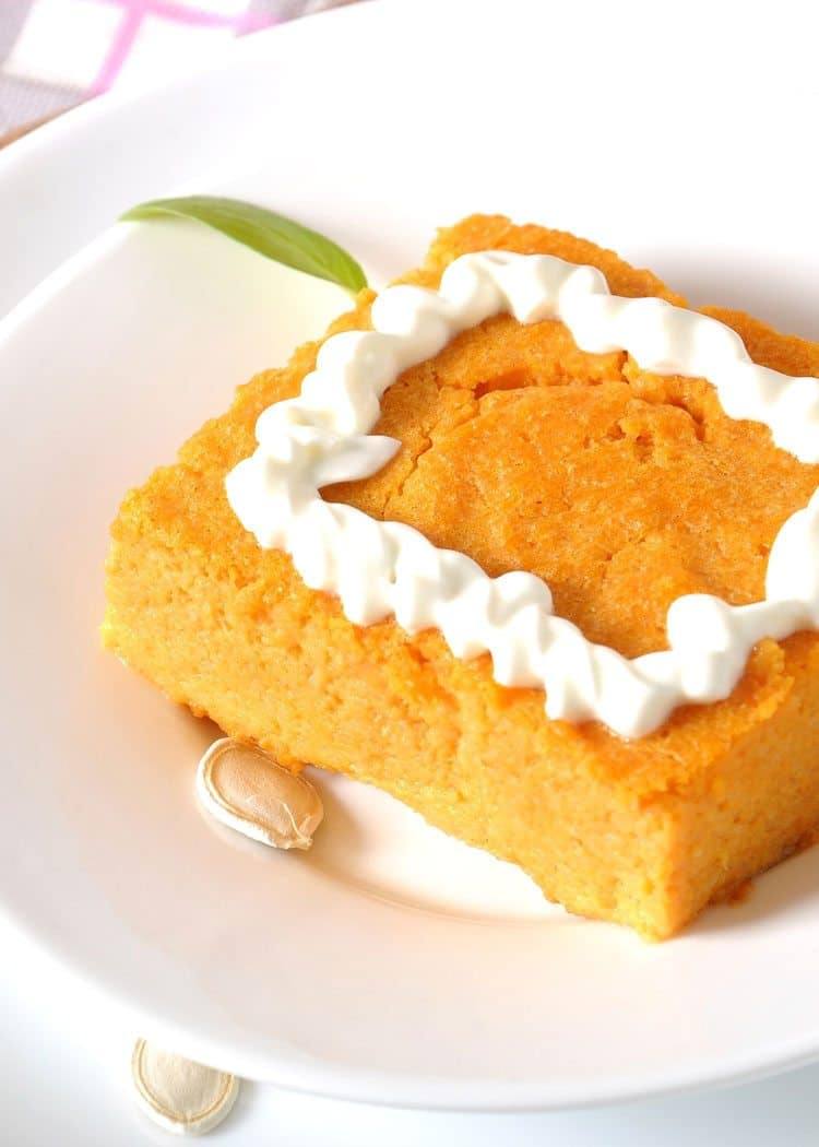 Slice of Weight Watchers crustless pumpkin pie topped with piped whipped topping in a white bowl