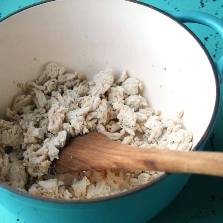 Ground turkey browning in a turquoise Dutch oven