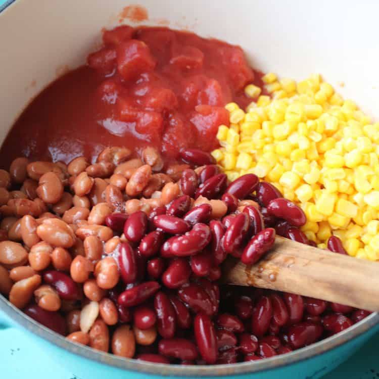 Tomatoes, tomato sauce and corn added to ground turkey in a pot for taco soup