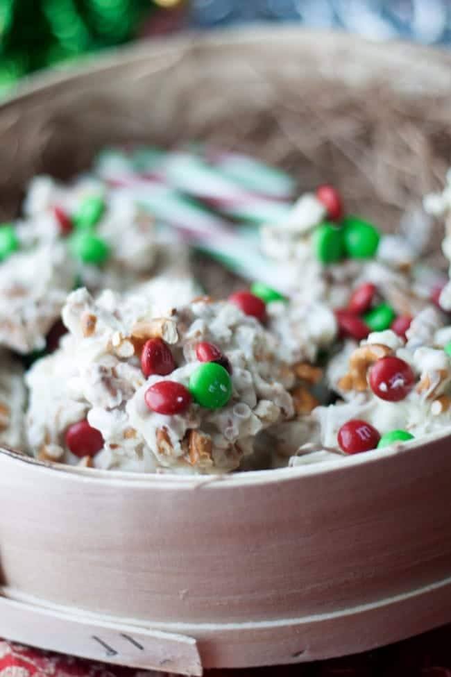 White chocolate pretzel clusters with red and green M&Ms in a wooden gift box