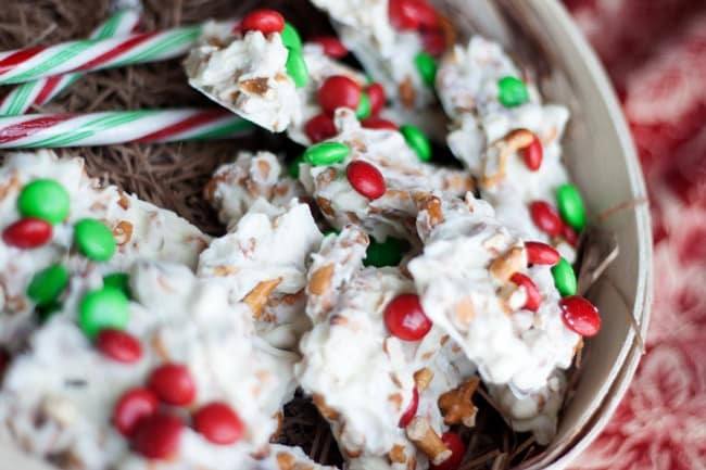 White chocolate pretzel clusters with holiday M&Ms and candy canes in a wooden box