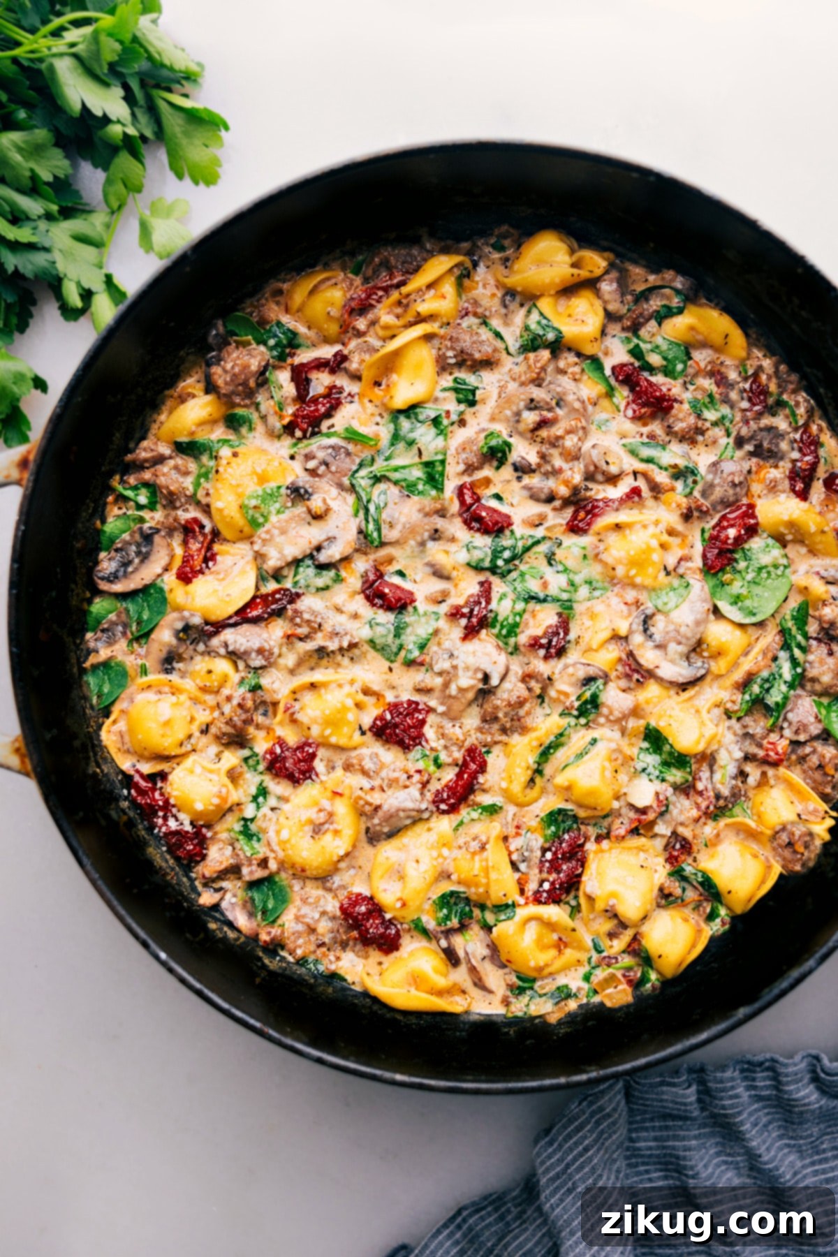 Irresistible Sausage Tortellini Bake Sausage Tortellini Bake fresh out of the oven, bubbling and garnished with fresh herbs, ready to be served.