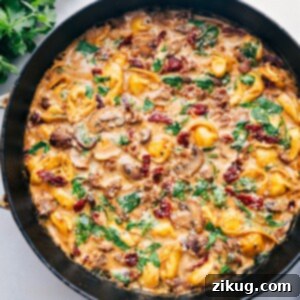 One-Skillet Sausage Tortellini Bake 2 Sausage Tortellini Bake fresh out of the oven, with a golden, bubbly top and garnished with fresh herbs.