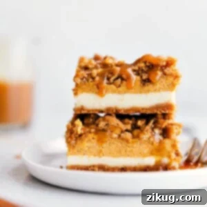 A top-down view of pumpkin cheesecake bars with caramel drizzle in a baking pan.
