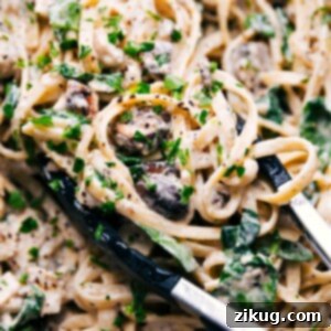 A tantalizing close-up of the finished creamy chicken pasta, beautifully plated and garnished with a sprinkle of fresh parsley, ready to be enjoyed.