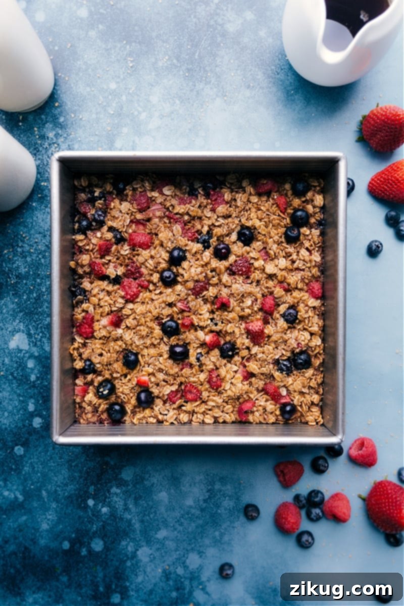 Overhead image of a beautifully baked oatmeal dish, topped with fresh berries and ready to be served.