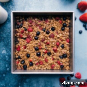Perfectly baked berry oatmeal squares topped with fresh berries.