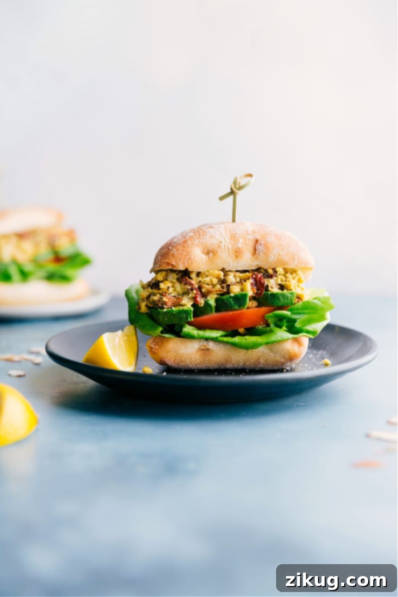 The Perfect Vegetarian Lunch: Pesto Chickpea Sandwiches Pesto Chickpea Sandwiches in a ciabatta bun with avocado, tomatoes, and lettuce, served on a plate.