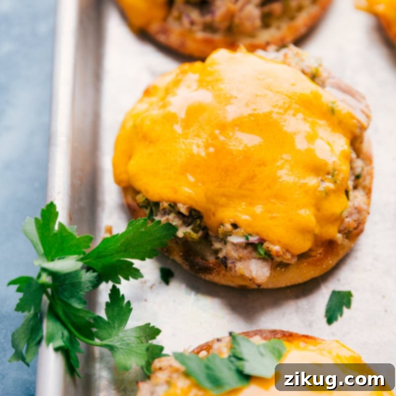 Tuna Melts are the best! Recipe via ChelseasMessyApron #dinner #quick #easy #simple #best #cheddar #bread #cheese #tuna #melts Two freshly made tuna melts on a wooden board, with perfectly melted cheese