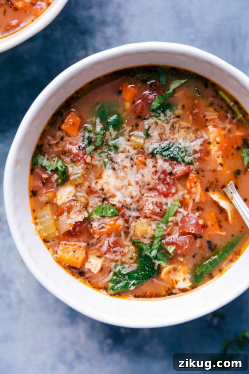 Delicious Crockpot Chicken Quinoa Soup with Parmesan A warm, inviting bowl of crockpot chicken quinoa soup, served fresh, generously topped with delicate shavings of Parmesan cheese.