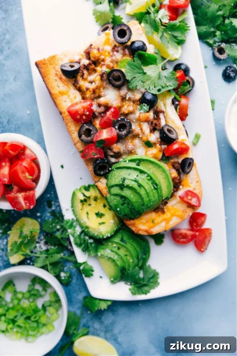 French Bread Taco Pizza: A quick and easy dinner combining taco flavors with a crispy French bread crust. Perfect for busy weeknights! Crispy French Bread Taco Pizza loaded with meat, cheese, and fresh toppings.