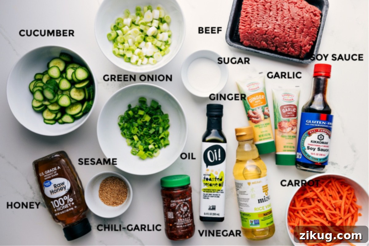 Ingredients In Korean Ground Beef All the ingredients for this Korean Ground Beef recipe are prepped and ready for easy assembly, including the meat, green onions, soy sauce, garlic, cucumber, ginger, carrot, vinegar, oil, chili garlic sauce, sesame oil, and honey, laid out on a clean surface.