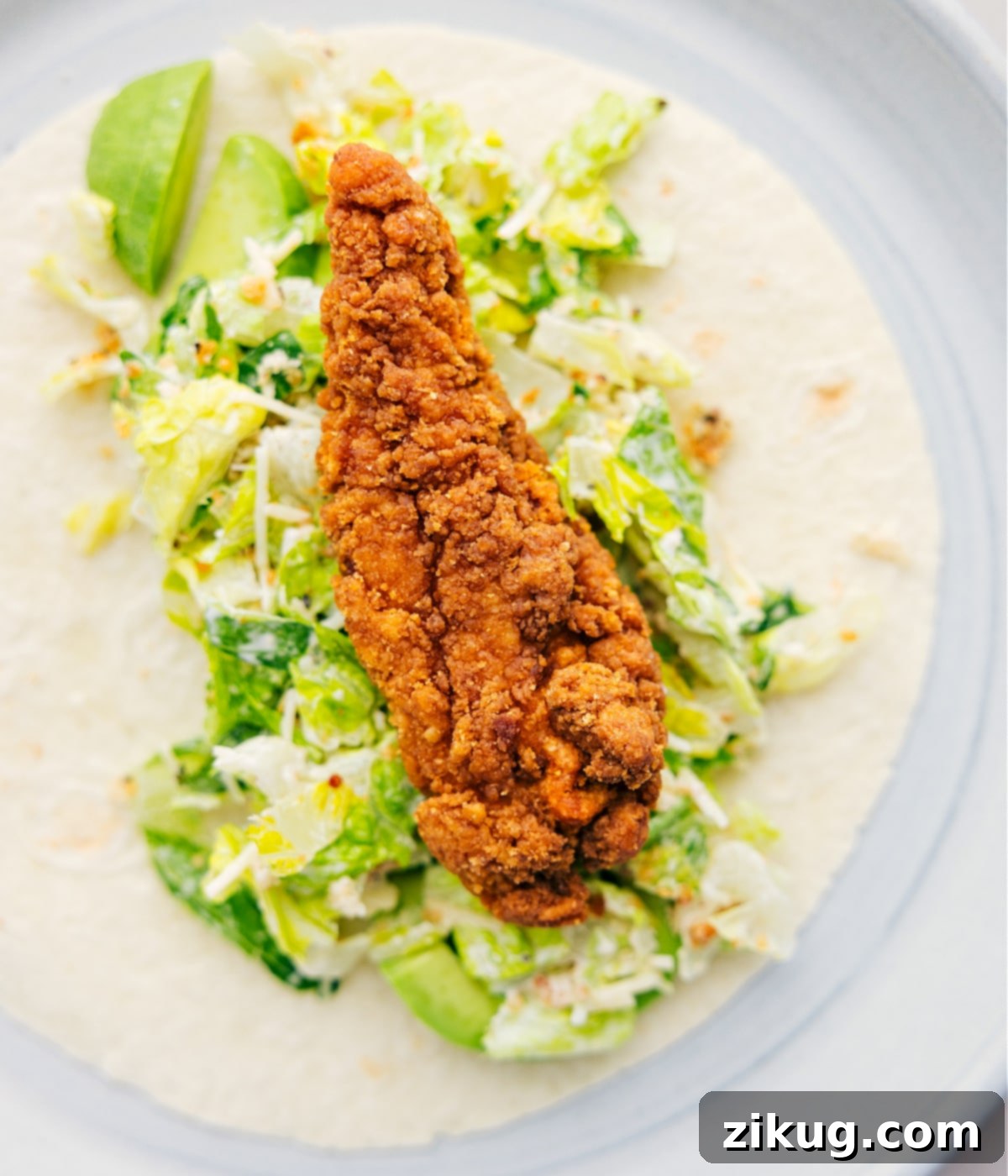 Piling in all the components of the Chicken Caesar Wrap inside a tortilla.