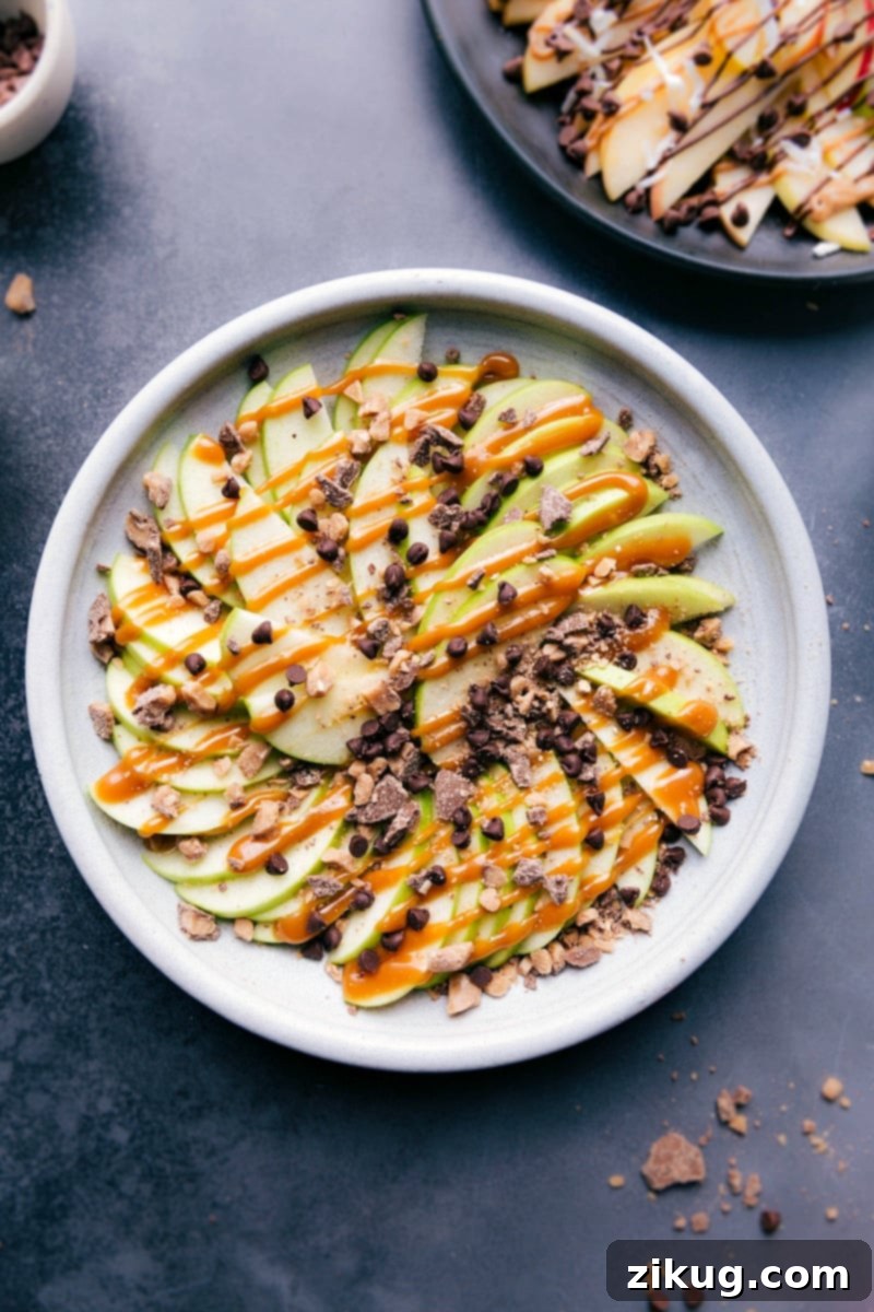 Easy, impressive, and super delicious! These Heath English Toffee Apple Nachos are a kid-friendly treat everyone will love. #applenachos #toffee #caramel #snacktime #fruit Overhead image of the heath Apple Nachos version, garnished with caramel sauce and English Toffee bits.