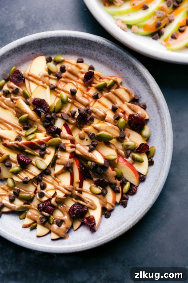 Almond Butter & Cranberry Apple Nachos: The ultimate healthy and delicious after-school snack, packed with flavor and nutrients! #applenachos #healthysnack #fruitlover #almondbutter #cranberry Overhead image of the almond butter, pepita, and cranberry version of these treats, showcasing healthy and vibrant apple nachos.