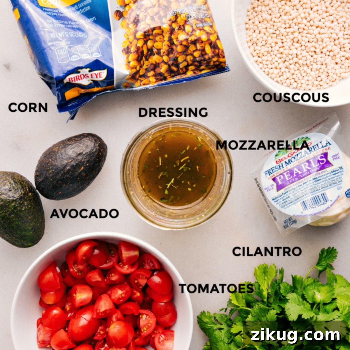 A colorful array of fresh ingredients prepped for the Summer Couscous Salad, including mozzarella pearls, cilantro, halved cherry tomatoes, diced avocado, cooked couscous, and roasted corn.