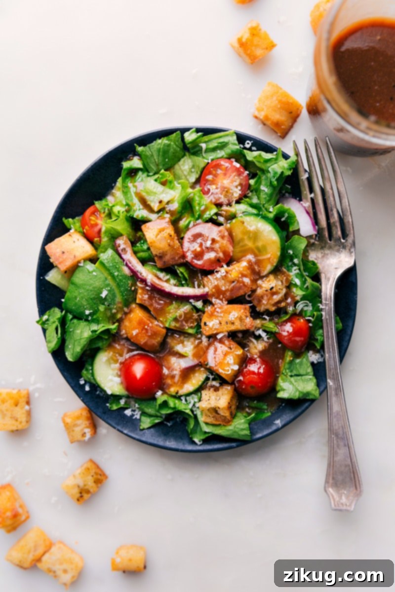 The ultimate simple Balsamic Vinaigrette recipe, whipped up in minutes with pantry staples for a balanced, tangy flavor. Perfect for healthy salads and roasted vegetables. #salad #saladdressing #clean #healthy #sidesalad #balsamic #vinaigrette Overhead image of the Balsamic Vinaigrette drizzled on a vibrant green salad, highlighting its perfect consistency and inviting color.