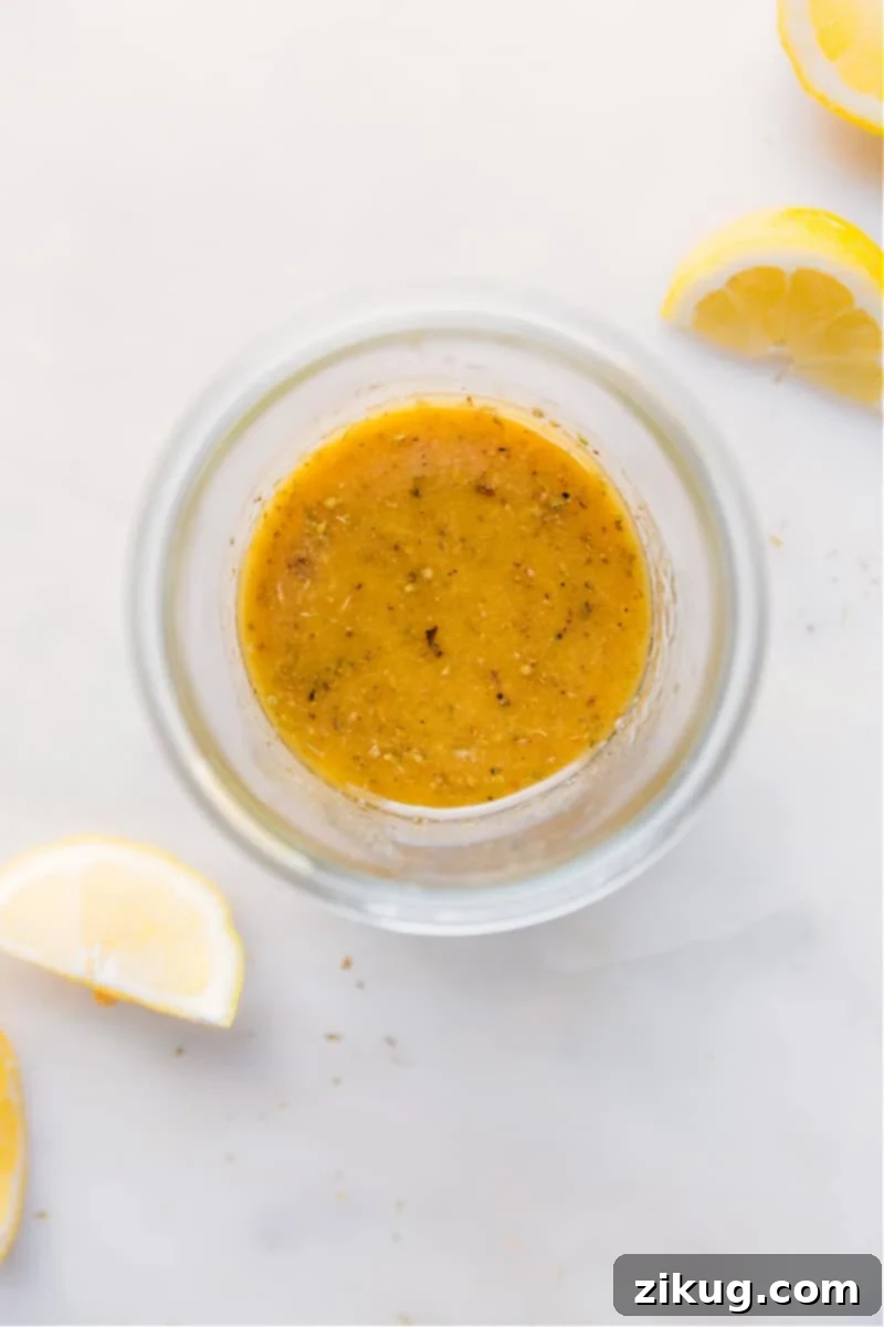Vibrant homemade Greek Salad Dressing in a glass jar, ready to be served