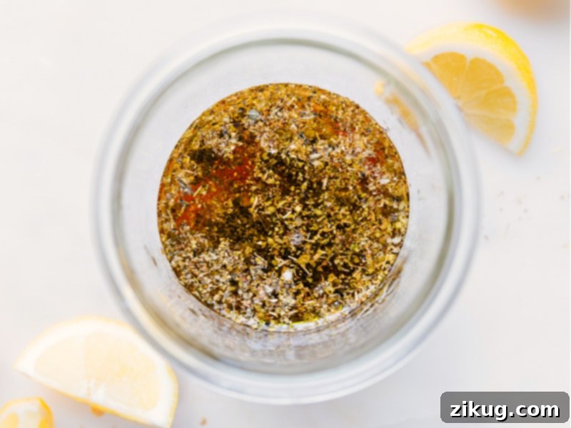 Process images showing all ingredients being added to a mason jar to make Greek Salad Dressing