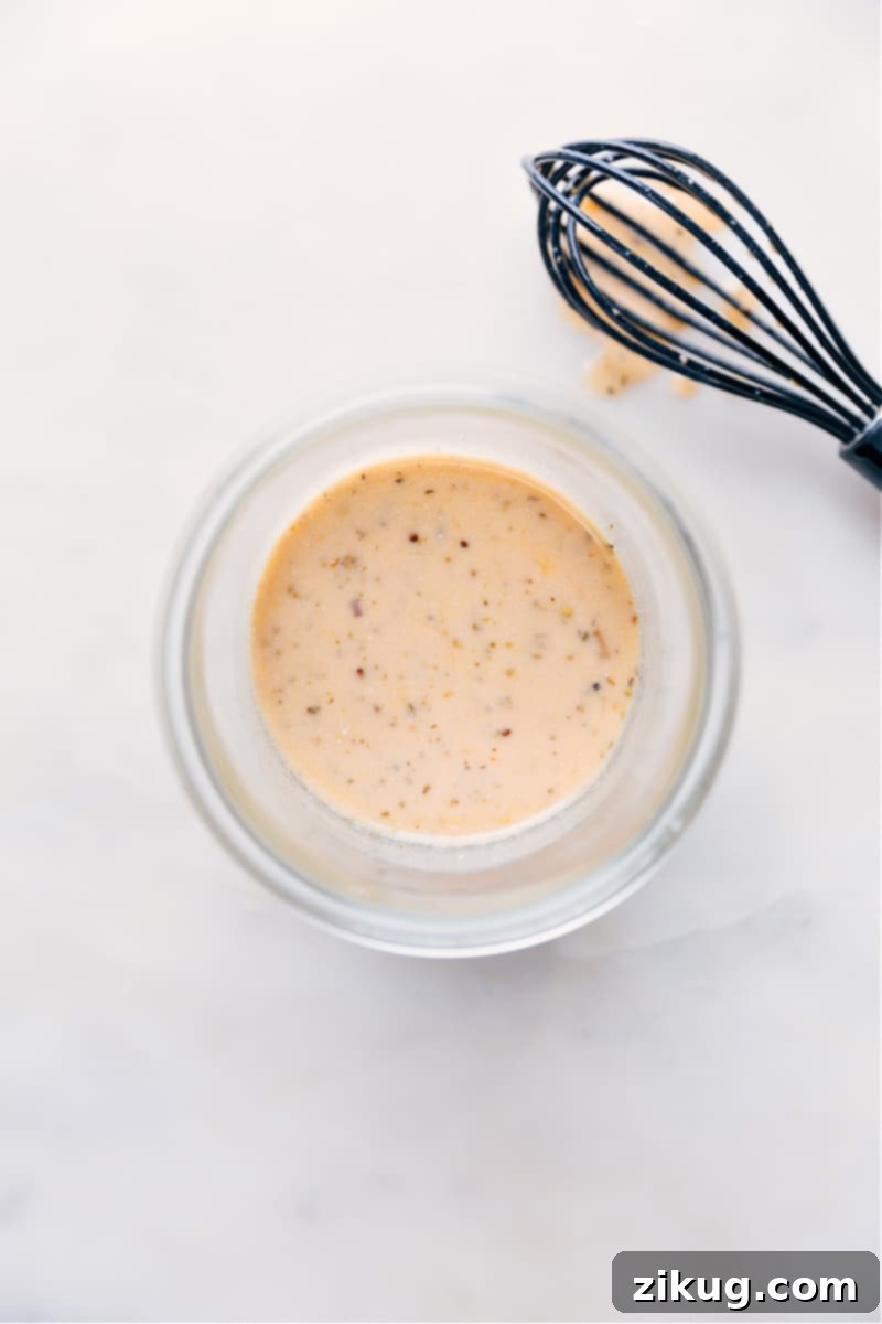 Herbed Italian Vinaigrette 7 A beautifully arranged serving of homemade Italian dressing in a jar, sitting next to a fresh salad bowl, ready to enhance the meal.
